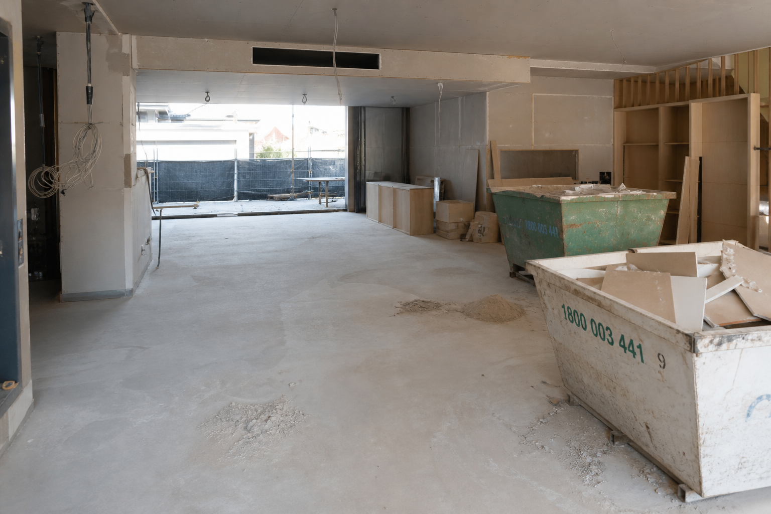 Rough clean stage with skip bins and plasterboard offcuts on a dusty site